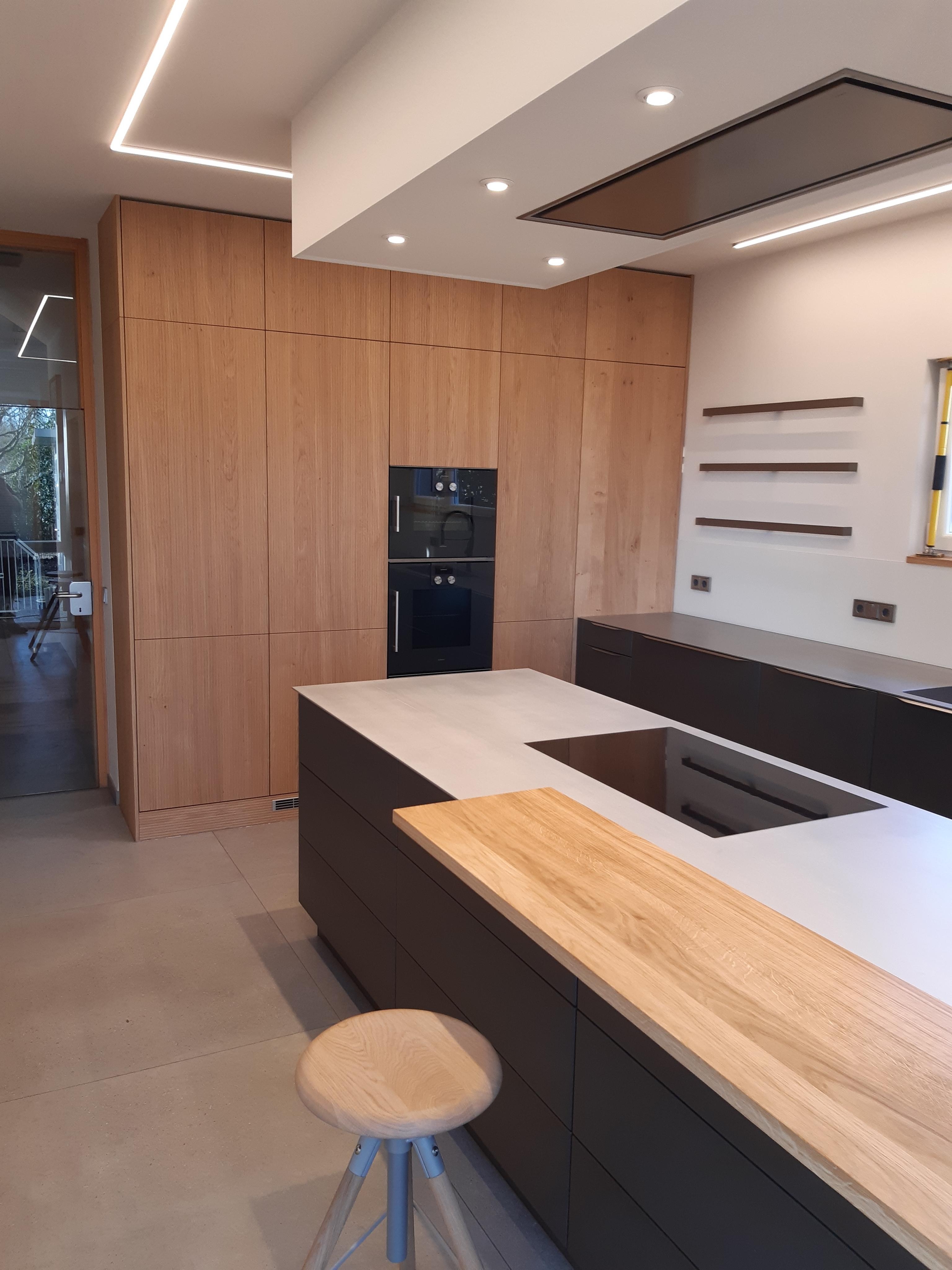 Leicht-Küche_mit_schwarzer_und_Front_in_Holzoptik_mit_Kücheninsel