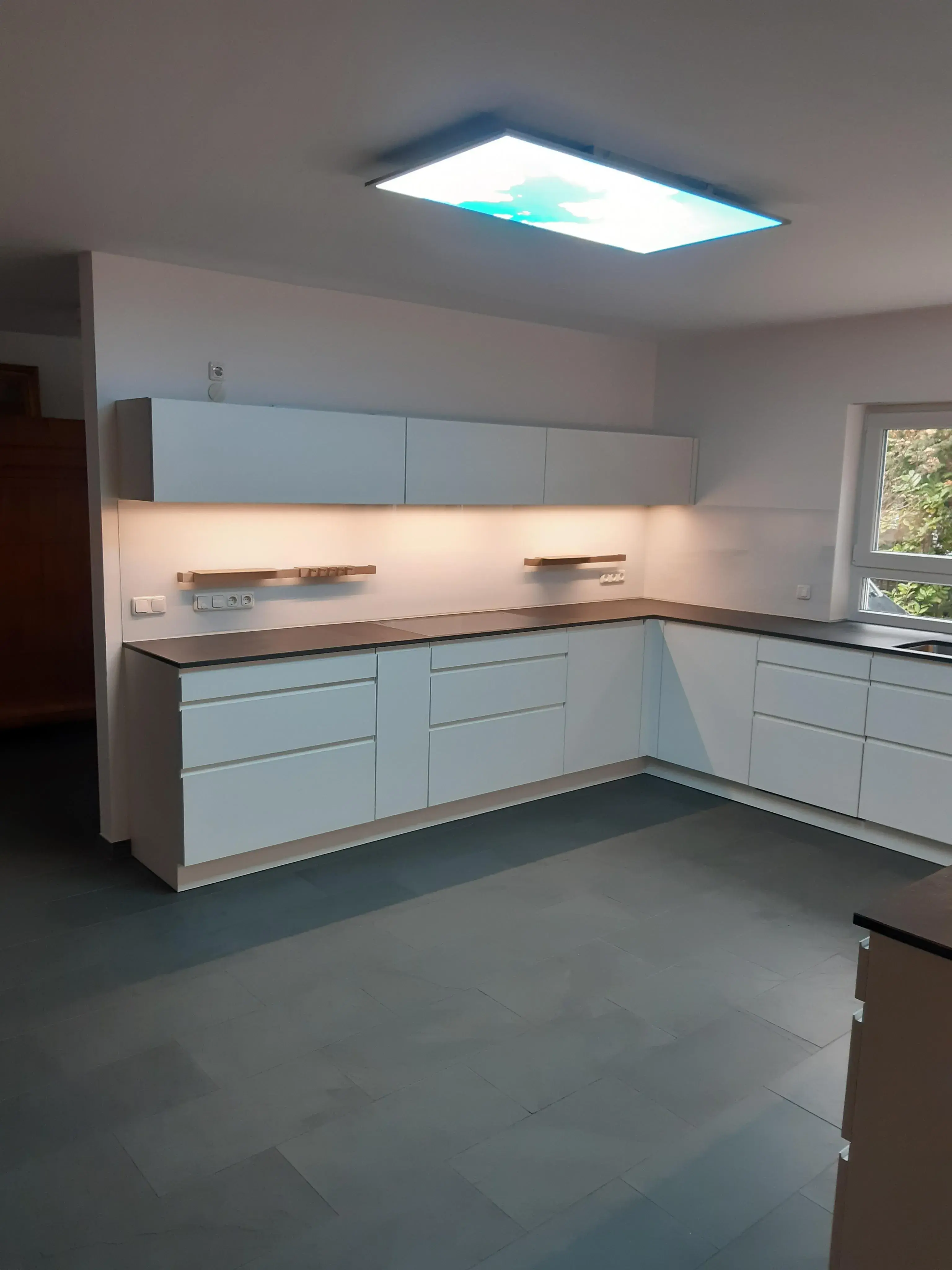 Leicht-Küche_mit-eleganten_Hängeschränken_in_Weiß_mit_Holzarbeitsplatte